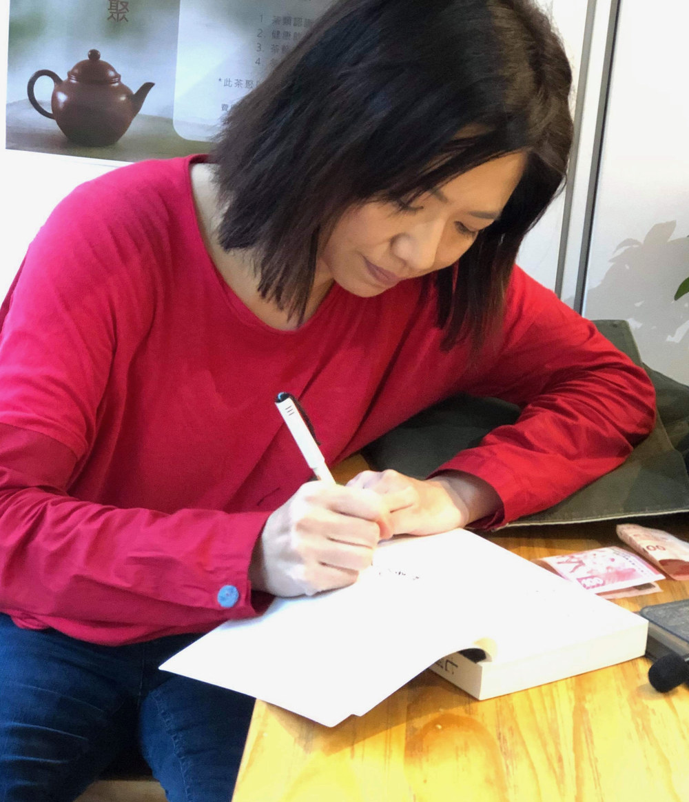 林喜兒低頭執筆書寫